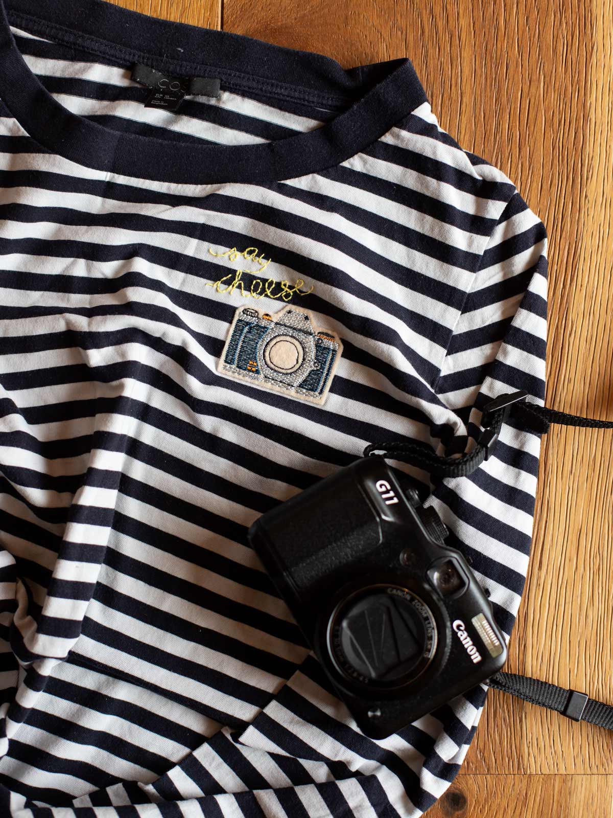 Aufnäher Kamera von Halfbird auf gestreiftem Shirt mit gelber, gestickter Schrift "say cheese"