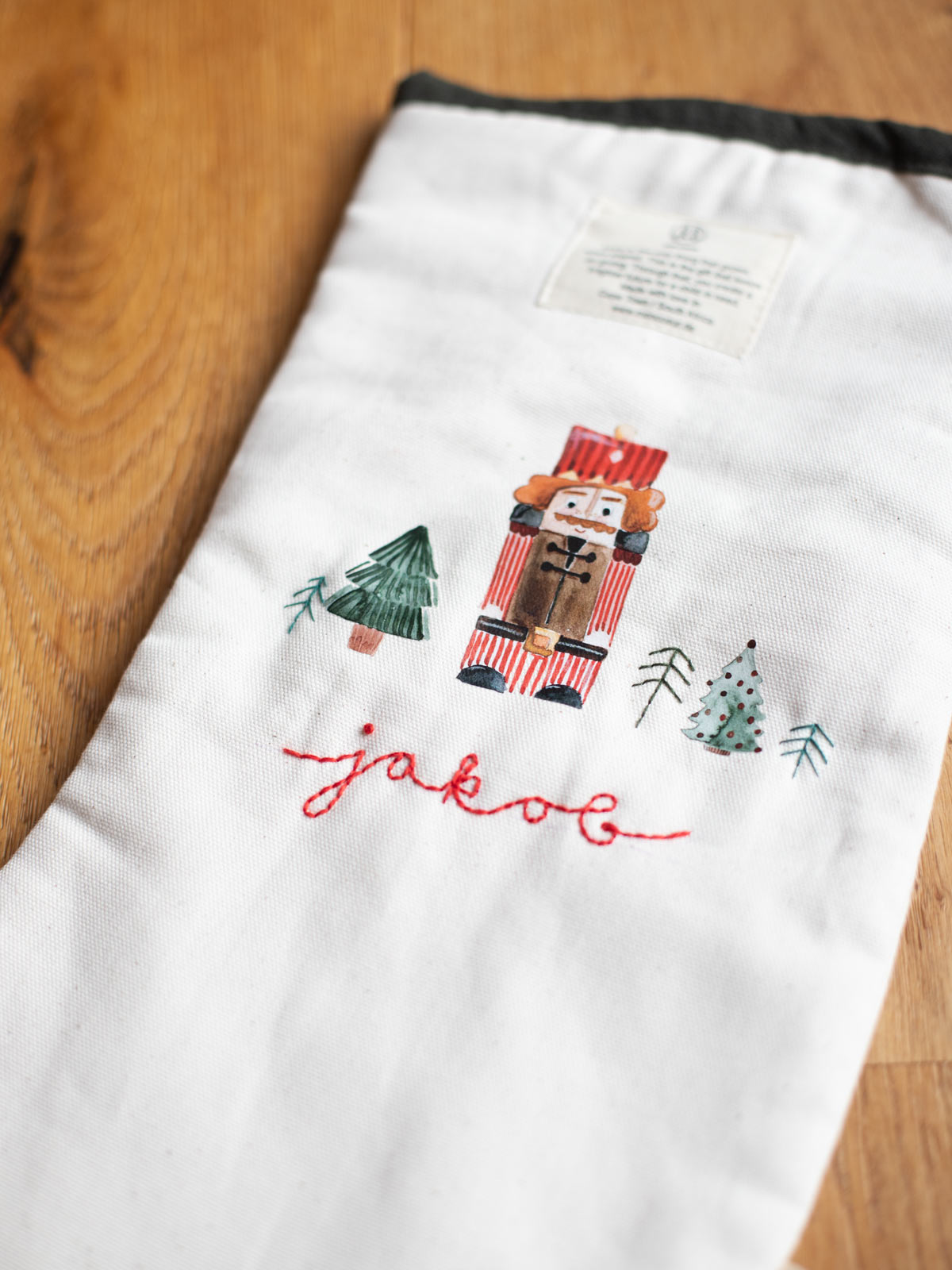 beiger Weihnachtsstrumpf von MON COEUR mit Weihnachts-Bügelbildern von Halfbird und gestickten Namen sowie Weihnachtsbäumen