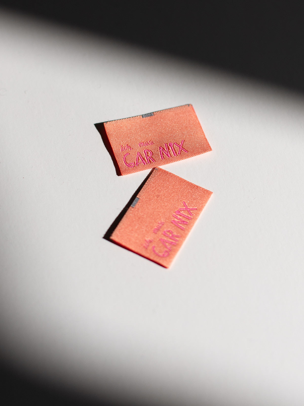 apricotfarbene Nähetiketten mit der neonlinken Aufschrift "ich muss gar nix" von Halfbird