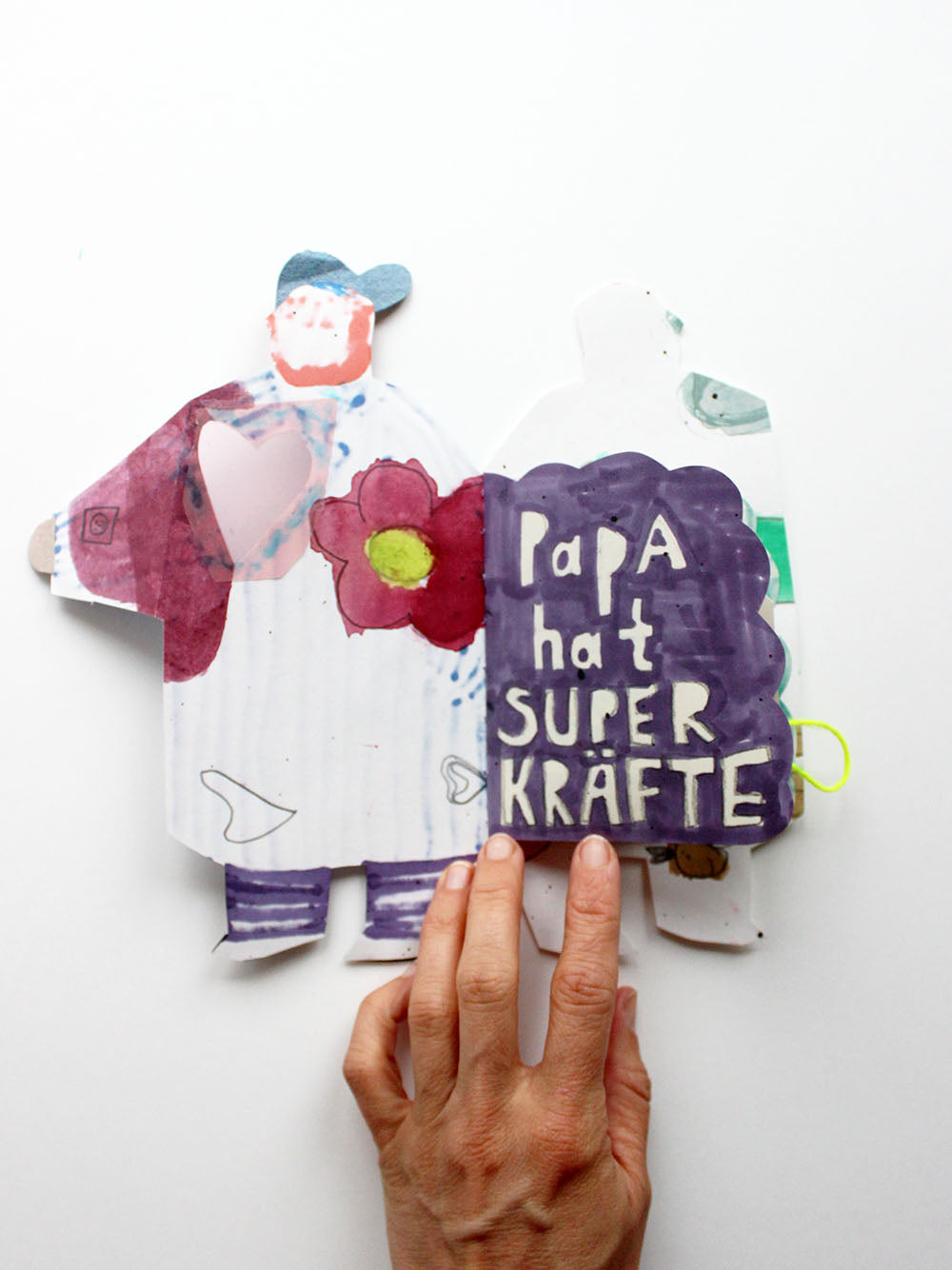 Aufgeschlagenes Superkräftebuch von Halfbird mit lila "Papa hat Superkräfte"-Seite