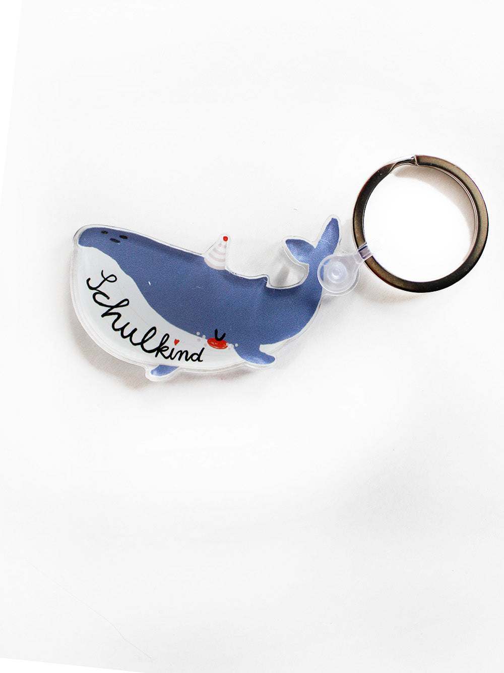 Ein Schlüsselanhänger mit Schlüsselring und Anhänger in Form eines Wals mit Schriftzug Schulkind in den Farben blau und weiß mit Partyhut