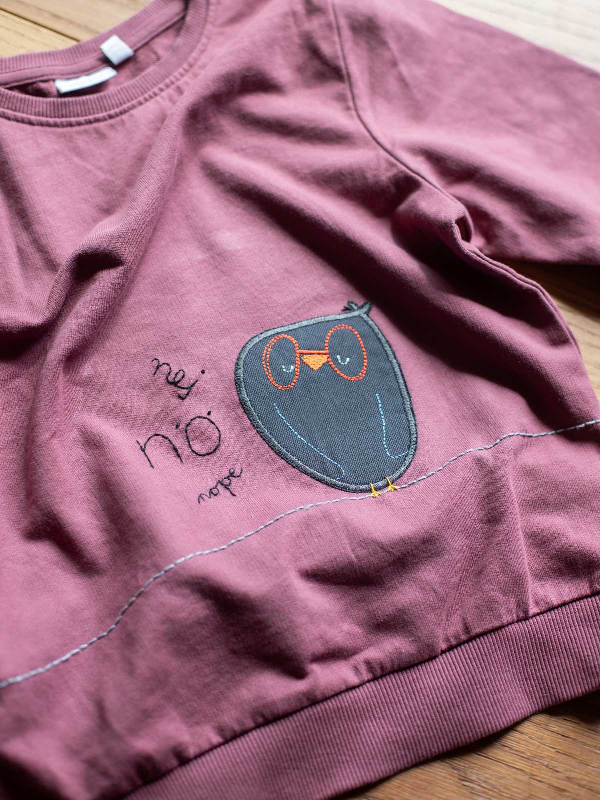 Knieflicken Eule von Halfbird auf
lilafarbenem Pullover