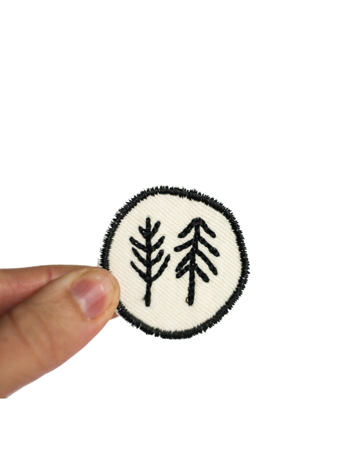 Aufnäher halfbird Bäume in rund in der Hand