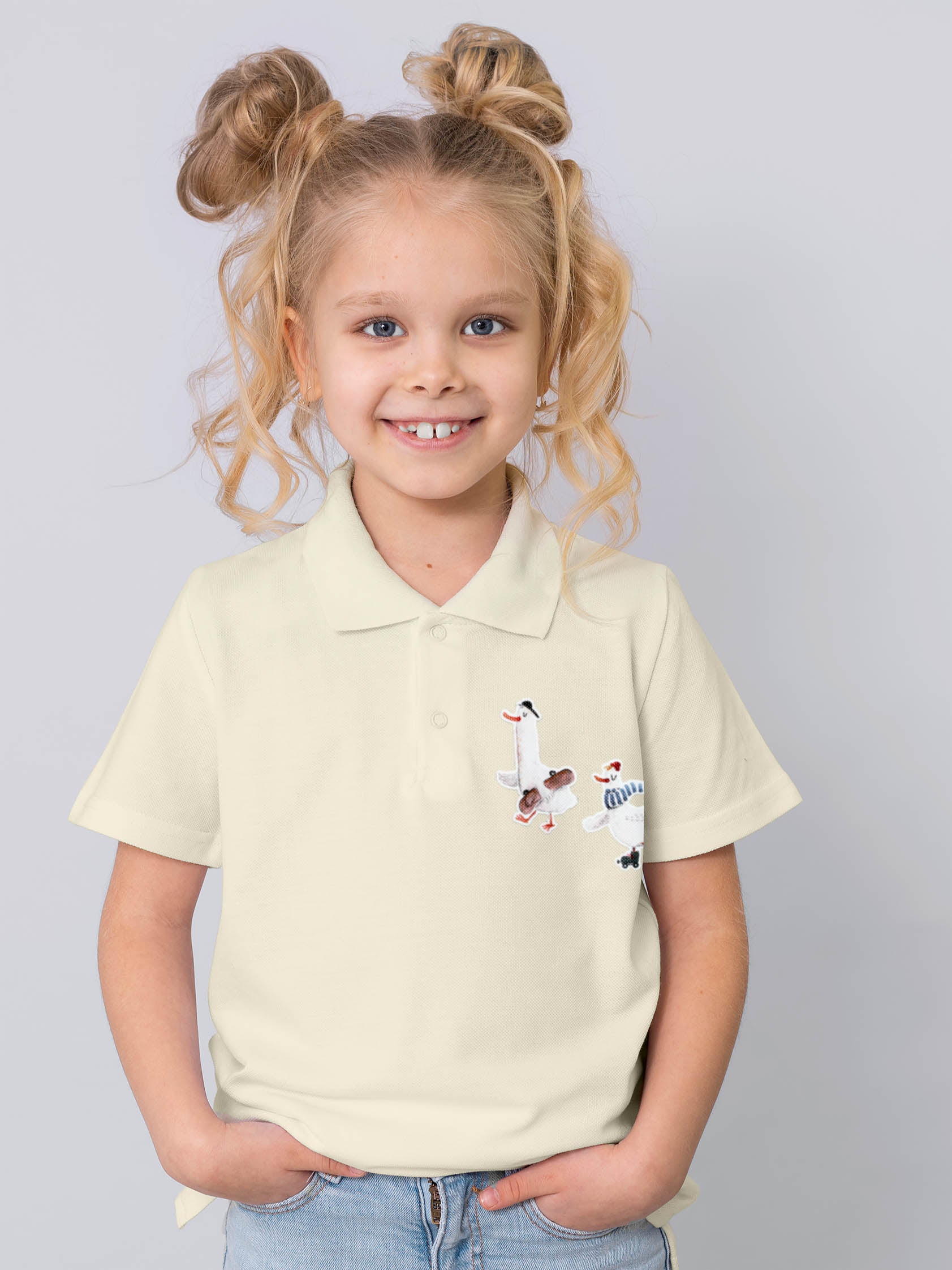 Mädchen mit Zöpfen trägt ein Poloshirt mit zwei Gänse Bügelbildern darauf