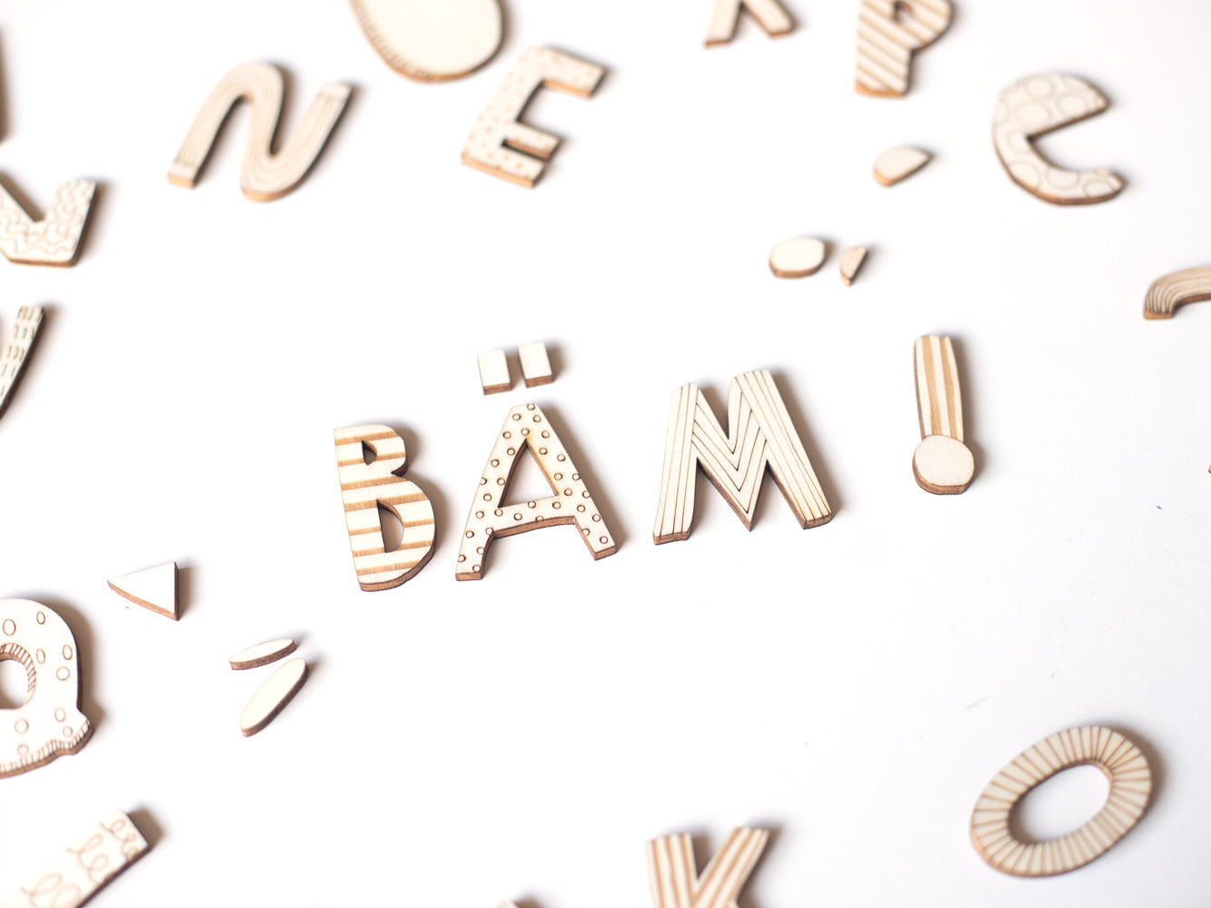 Mit Holzbuchstaben das Wort Bäm gelegt mit Ausrufezeichen