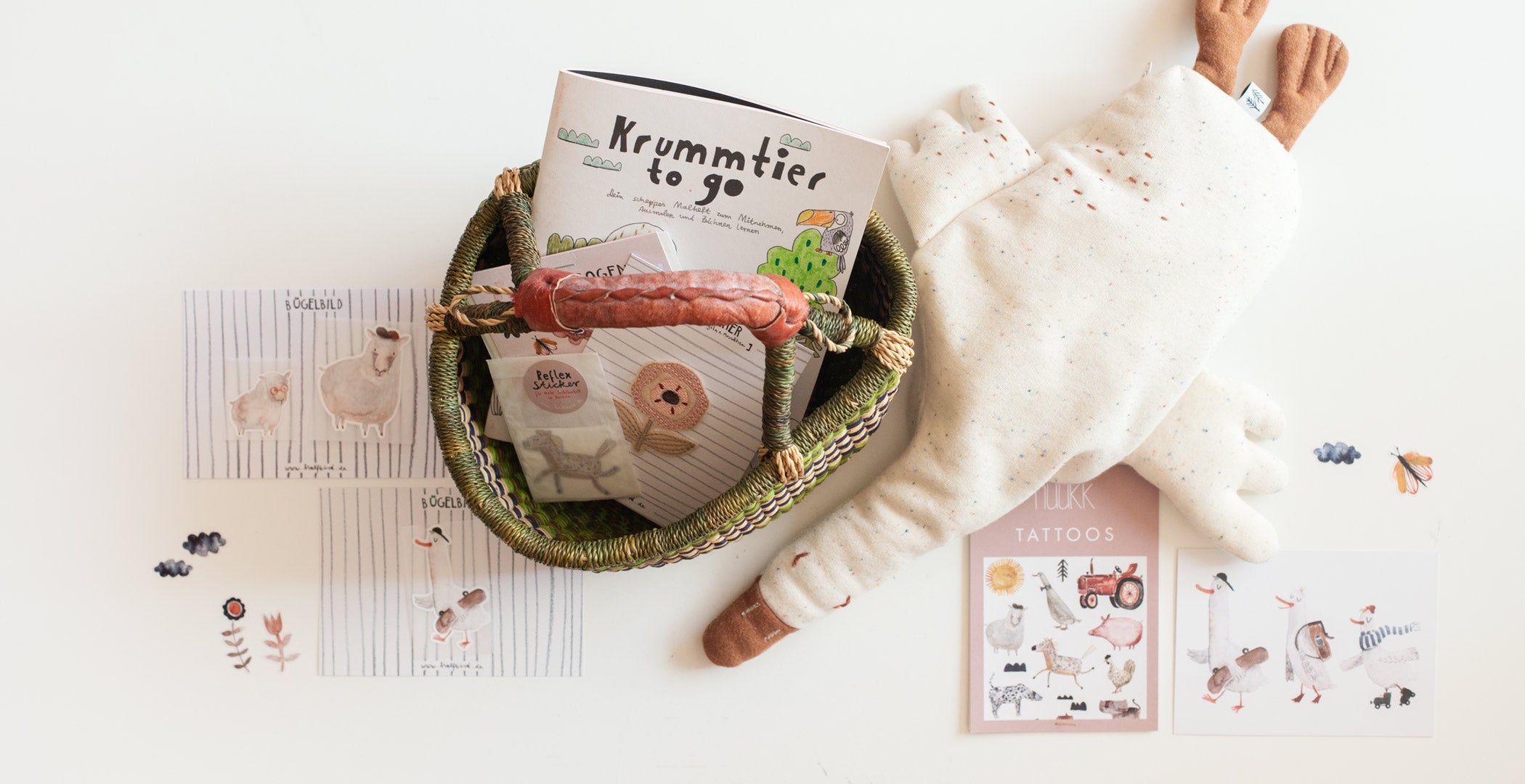 Ideen für das Osterkörbchen im flatylay, mit dabei gans gerda wärmetier, sticker, blumen bügelbilder und Tier tattoos