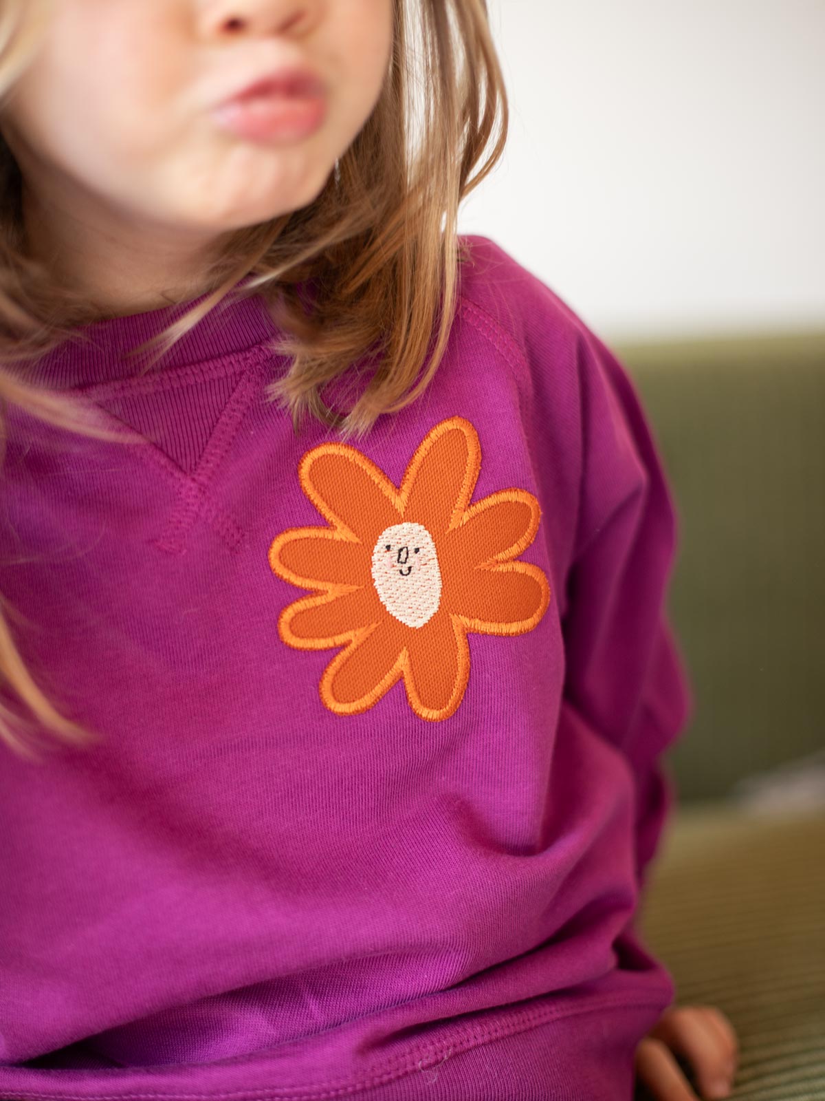 Kind mit Pulli mit Aufnäher "Blume groß" von Halfbird