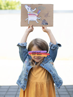 Kind mit Einhorn-Demoplakat und Jeansjacke mit FCK NZS-Einhorn-Aufnäher von Halfbird