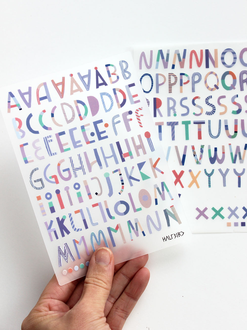 Hand mit randlosen Buchstaben Bügelbildern von Halfbird