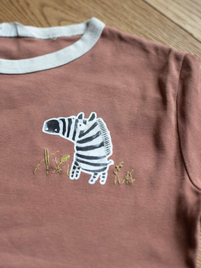 tshirt in rost mit bügelbild zebra und gras daneben in grün