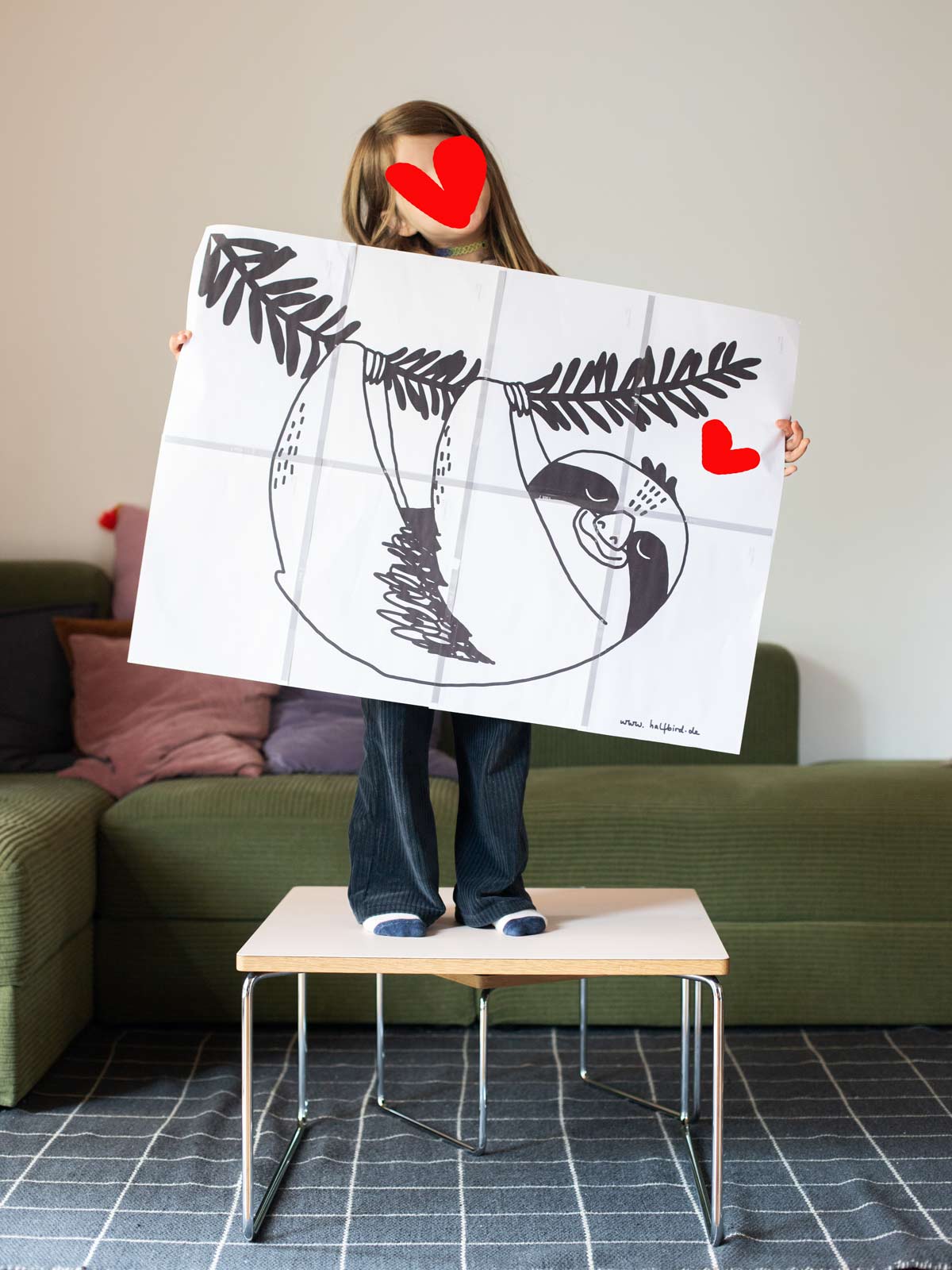 Kind hält Malvorlage vom Fensterbild Faultier von Halfbird