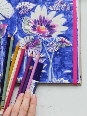 Polychromos und Brush Pen aus dem Stifteset "Seerose" von Halfbird neben Illustration im Skizzenbuch