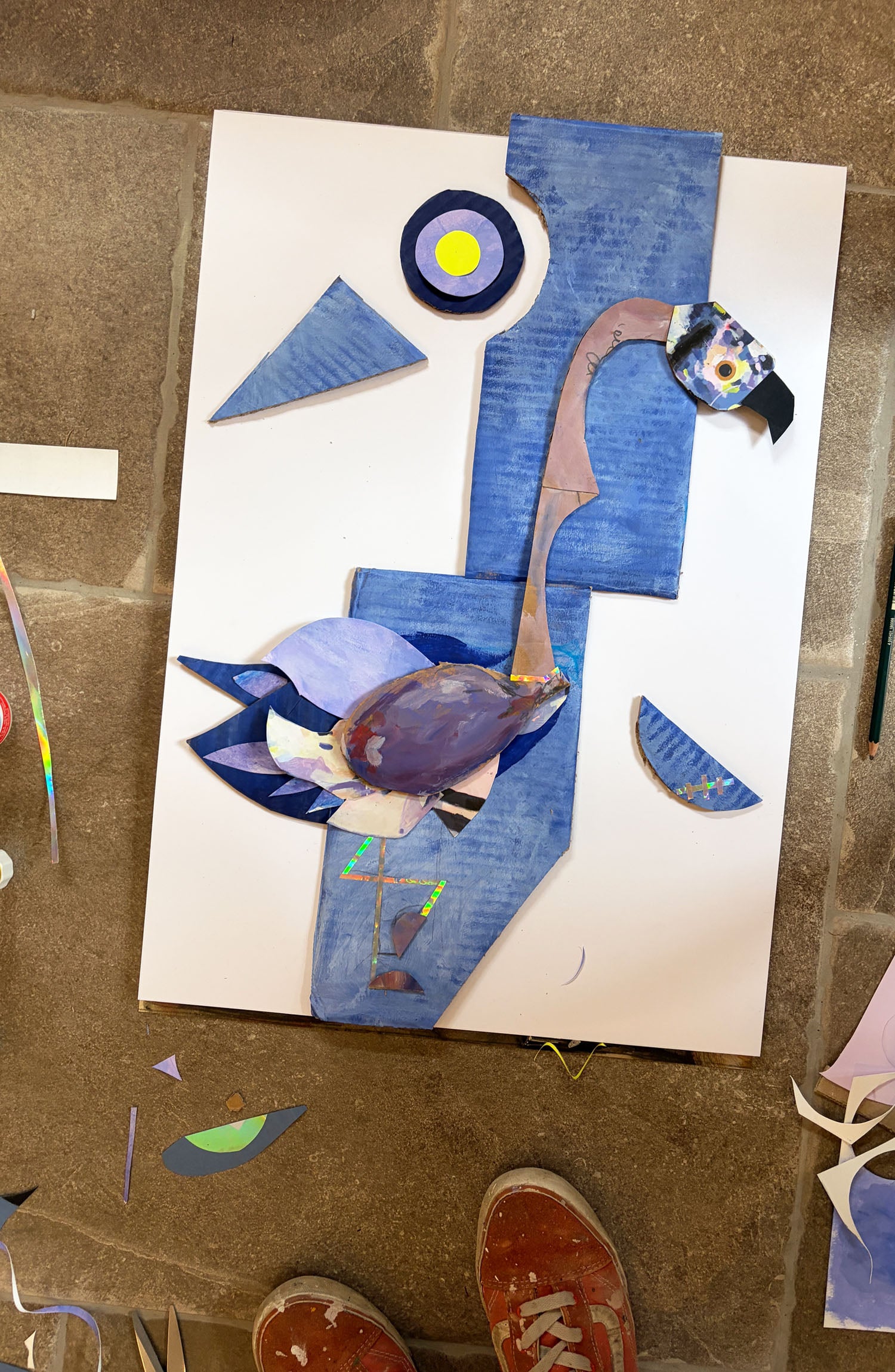 ein Kunstwerk auf dem Boden in blau lila aus verschiedenen Schnipsel ergeben einen Storch und einen Flamingo