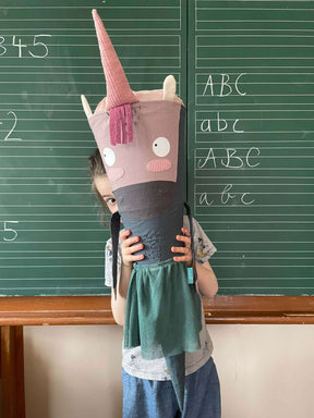große Einhorn Schultüte ohne Glitzer, aber mit richtig viel Charme vor einer Schultafel. Für Mädchen oder Jungs zum Schulanfang. Sie trägt einen Tüllrock und hat Arme sowie Brusthaar