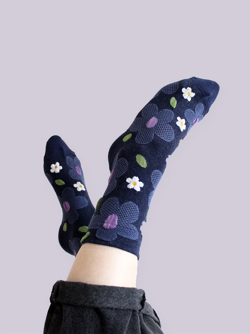 Tragebild von dunkelblauen Socken mit erhabener Struktur mit großen taubenblauen und weißen Blumen