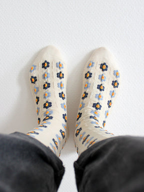 Tragebild von Cremefarbenen Socken mit Stickerei Anmutung und hellblauen und dunkelblauen Blumen mit gelb/roten Blütenstempeln