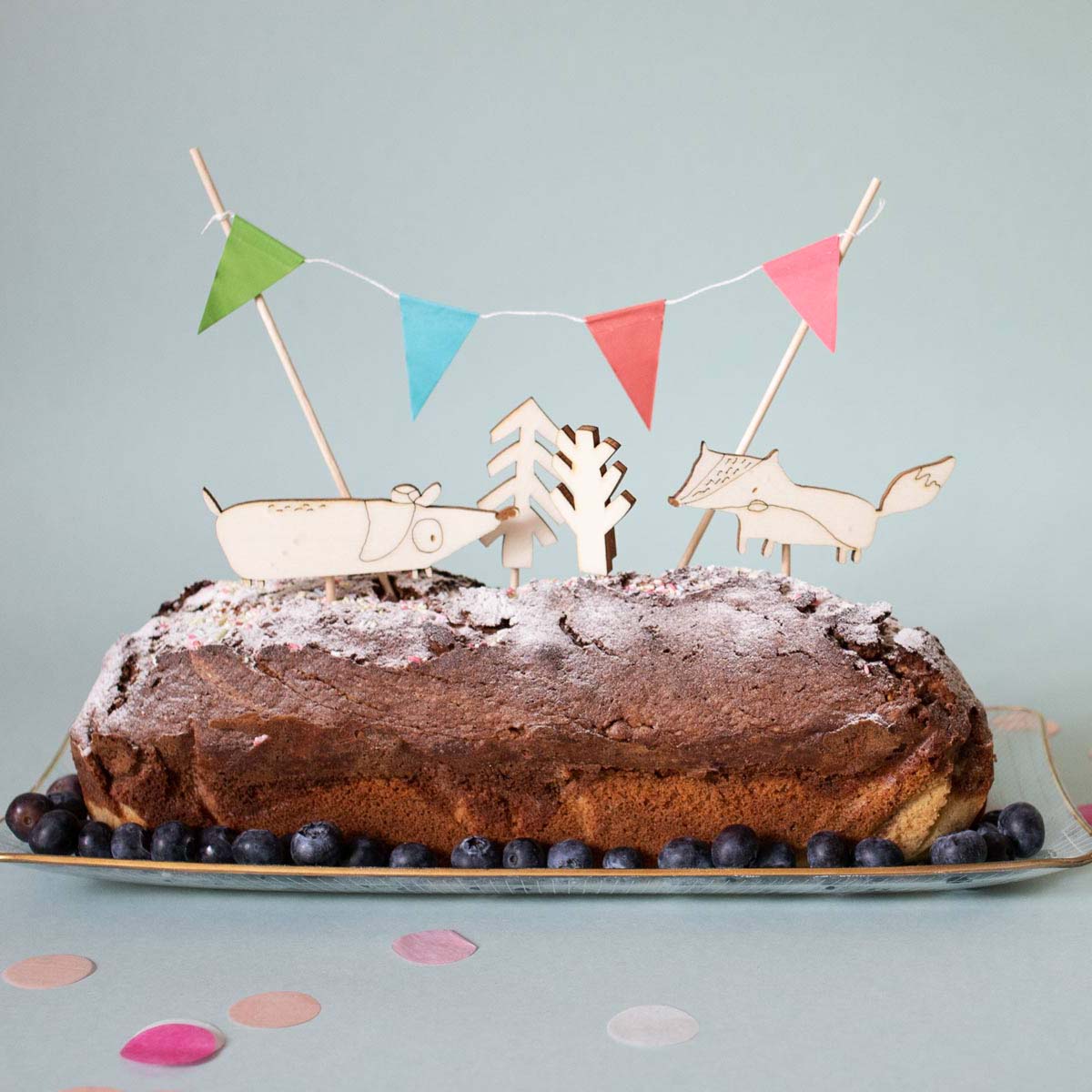 Geburtstagskuchen mit cake toppern aus holz, ein dackel, ein fuchs und bäume sowie eine Girlande aus papier 