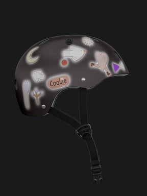 ein helm bei nacht der reflektiert weil er angestrahlt wird. er ist mit reflex stickern von halfbird beklebt. darunter ein vogel, herz, formen, mond und sterne