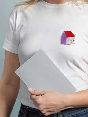 Frau mit weißem T-shirt und einem Haus aufnäher auf der brust in lila rot
