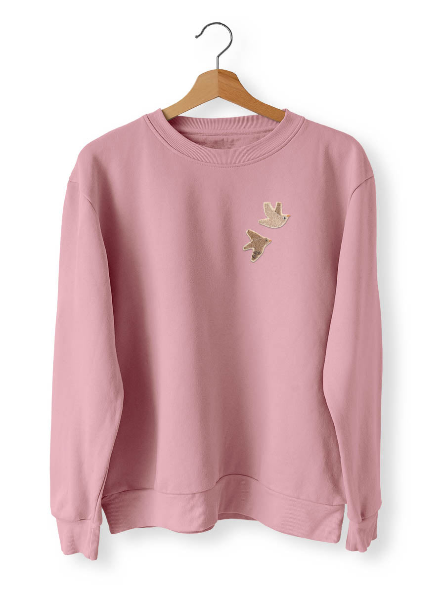 zwei Vogel Aufnäher aufgebügelt auf einem rosa Pullover